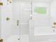 A luxurious bathroom showcases a glass-enclosed shower with gold fixtures and a soaking tub with a window above it at 48 Sherwood Nw Ct # Sw48, Concord, NC 28027