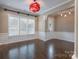 Bright dining area featuring wainscoting, gleaming hardwood floors, and modern light fixture at 507 Quicksilver Trl, Fort Mill, SC 29708