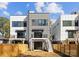 Back exterior of modern townhouse featuring fenced yard, stairs, and balconies at 217 Keswick Ave, Charlotte, NC 28206