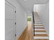 Bright hallway featuring hardwood floors, white walls, staircase, and glass door to the outdoors at 217 Keswick Ave, Charlotte, NC 28206