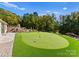 Sprawling backyard featuring a putting green, stone steps leading to an outdoor terrace, and mature trees at 2723 Providence Pine Ln, Charlotte, NC 28270