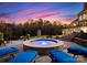 Inviting backyard with hot tub, lounge chairs, and lush landscaping at dusk at 2723 Providence Pine Ln, Charlotte, NC 28270