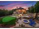 Expansive backyard featuring a putting green, hot tub, stone patio, and outdoor seating areas at 2723 Providence Pine Ln, Charlotte, NC 28270