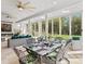 Elegant indoor dining area with a fireplace, floor to ceiling windows overlooking greenery and access to outdoor spaces at 2723 Providence Pine Ln, Charlotte, NC 28270