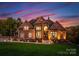 Elegant brick home featuring a manicured lawn and walkway with landscape lighting at 2723 Providence Pine Ln, Charlotte, NC 28270