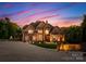 Stately brick home with manicured lawn and illuminated driveway, showcasing elegance at 2723 Providence Pine Ln, Charlotte, NC 28270