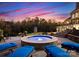 Hot tub at twilight with lounge chairs, lush greenery, and a view of the multi-story home at 2723 Providence Pine Ln, Charlotte, NC 28270