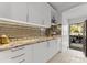 Modern kitchen featuring granite countertops, white cabinetry, stainless appliances, and a mirrored backsplash at 2723 Providence Pine Ln, Charlotte, NC 28270