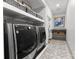 Laundry area with modern washer and dryer set, ample storage, and attractive tile flooring at 2723 Providence Pine Ln, Charlotte, NC 28270