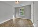 Bright bedroom with light gray walls, wood-look flooring, and a window at 305 Gooch St, Lancaster, SC 29720