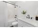 Clean bathroom with white vanity, marble tile, and bathtub shower combo at 101 N Smallwood Pl, Charlotte, NC 28216