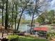 Scenic view of backyard with a covered dock, lush greenery, and lake access at 377 Riverwood Rd, Mooresville, NC 28117