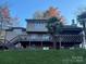 Stunning backyard features a large deck with stairs, a beautiful lawn, and mature palm trees at 377 Riverwood Rd, Mooresville, NC 28117