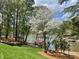 Lush backyard with lake access, a covered dock, and mature trees providing shade at 377 Riverwood Rd, Mooresville, NC 28117