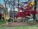 Charming exterior showcasing mature trees, lush landscaping, and a lovely facade at 377 Riverwood Rd, Mooresville, NC 28117