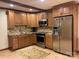 Cozy kitchenette with wood cabinets, stainless steel appliances, and mosaic backsplash at 377 Riverwood Rd, Mooresville, NC 28117