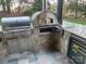 Outdoor kitchen with stainless steel grill, pizza oven, and beverage fridge at 377 Riverwood Rd, Mooresville, NC 28117