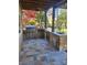 Covered outdoor kitchen featuring stainless steel appliances, stone counters, and tiled flooring at 377 Riverwood Rd, Mooresville, NC 28117