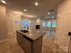 Open-concept living space with wood floors, kitchen island, fireplace, and ample natural light at 4049 Port Richmond Ave # 11, Gastonia, NC 28056