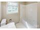 Bathroom featuring a standard toilet, window and a combined bathtub and shower with white tile at 349 Dublin Ct, Gastonia, NC 28054