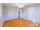 Bedroom with hardwood floors, ceiling fan, and a double-door closet with an adjacent doorway at 349 Dublin Ct, Gastonia, NC 28054