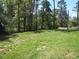 Large grassy backyard surrounded by trees, offering a private outdoor space at 4986 6Th Sw St, Catawba, NC 28609