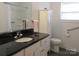 Clean bathroom with a black countertop vanity, white cabinetry, and a shower-tub combination at 4986 6Th Sw St, Catawba, NC 28609