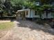 Charming single-story home featuring a welcoming covered entry and white siding, nestled on a spacious lot with mature trees at 7608 Kershaw Camden Hwy, Kershaw, SC 29067