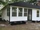 Charming house with a new black roof, white siding, and a beautiful touch of pink flowers in the front yard at 7608 Kershaw Camden Hwy, Kershaw, SC 29067