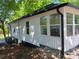 Exterior view showcasing the white siding, black trim, and large windows that bring plenty of natural light to the house at 7608 Kershaw Camden Hwy, Kershaw, SC 29067