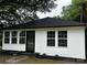 Charming house with a black roof, white siding, and well-maintained landscaping at 7608 Kershaw Camden Hwy, Kershaw, SC 29067