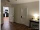 Hallway view with door to kitchen, storage, and wood floors at 7608 Kershaw Camden Hwy, Kershaw, SC 29067