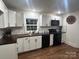 Modern kitchen equipped with stainless sink, dark butcher block countertops, white shaker cabinets, and black appliances at 7608 Kershaw Camden Hwy, Kershaw, SC 29067