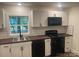 A well lit kitchen with black appliances, white cabinetry, and subway tile at 7608 Kershaw Camden Hwy, Kershaw, SC 29067