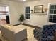 Cozy living room with stylish seating arrangements, bright windows, and a view of an updated kitchen at 7608 Kershaw Camden Hwy, Kershaw, SC 29067