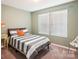 A cozy bedroom with an accent colored pillow sitting on the bed, and a big bright window at 1176 Whitehall Hill Rd, York, SC 29745