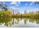 Calm lake view featuring reflections of trees against a blue sky with scattered clouds at 1176 Whitehall Hill Rd, York, SC 29745