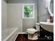 Clean bathroom featuring tile, window, toilet, vanity, and dark floors at 3337 Eastway Dr, Charlotte, NC 28205