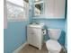 Cozy bathroom features a white vanity, a mirror, and a toilet against pastel blue walls at 1166 Montford Dr, Charlotte, NC 28209