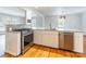 Modern eat-in kitchen featuring stainless steel appliances, white cabinets, and hardwood floors for seamless elegance at 1166 Montford Dr, Charlotte, NC 28209