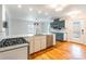 Modern kitchen with stainless steel appliances, white countertops, and stylish blue cabinets. Overlooks hardwood floored living area at 1166 Montford Dr, Charlotte, NC 28209