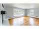 Spacious living room with hardwood floors, fireplace, and large windows providing natural light throughout the space at 1166 Montford Dr, Charlotte, NC 28209