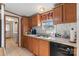 Functional kitchen with wood cabinets, black appliances, and a window overlooking yard at 119 Loray Ln, Statesville, NC 28625