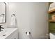 Simple half bathroom with white vanity and green accent wall at 1547 Rye Rd, Mount Holly, NC 28120