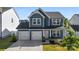 Two-story house with gray siding, two-car garage, and landscaping at 1547 Rye Rd, Mount Holly, NC 28120