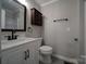 This bathroom features a modern vanity with marble countertop, dark fixtures, and coordinating wood accents at 26034 Misty Way Dr, Fort Mill, SC 29708