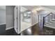 Hallway leading to an updated kitchen, featuring dark hardwood floors and neutral paint colors at 26034 Misty Way Dr, Fort Mill, SC 29708