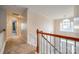 Upstairs hallway with carpeted floors and wooden railings at 5225 Rocky River Crossing Rd, Harrisburg, NC 28075