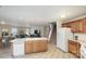 Open-concept kitchen with central island, tile flooring, and staircase access in a naturally lit space at 135 Anastasia Ln, Lincolnton, NC 28092