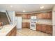 Bright kitchen with wooden cabinets, tiled floor, and white appliances offers a practical cooking space at 135 Anastasia Ln, Lincolnton, NC 28092